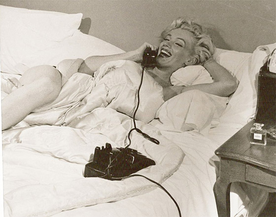 Marilyn para uma sessão de fotos não publicada, em 1953, com o perfume na mesa de cabeceira.